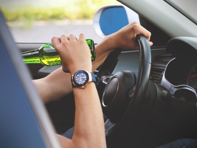Person drinking beer in car