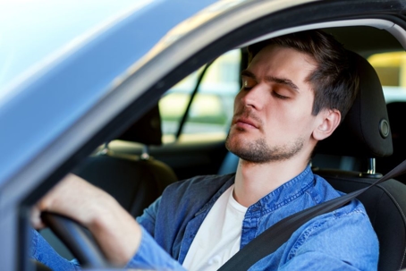 man sitting in car with eyes closed
